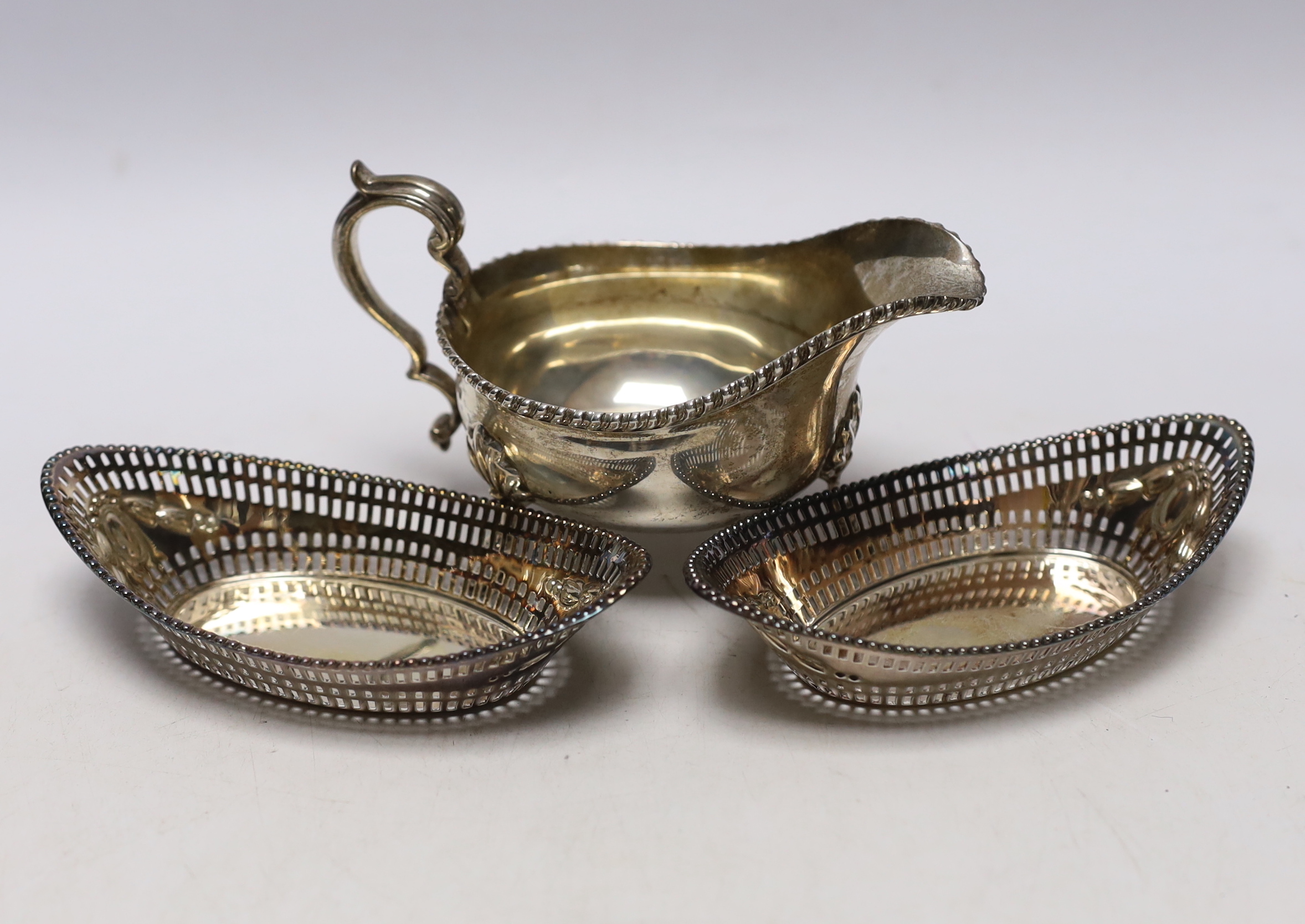 A George V silver sauceboat, Thomas Bradbury & Sons, Sheffield, 1919 and a pair of earlier pierced silver oval bonbon dishes, 13.8cm, 11.3oz.